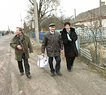 Members of the comission walking with a mobile ballot box